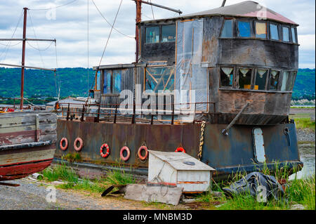 Homer, Alaska, USA - 28. Juni 2017: ein Boot, umgeben von anderen faulenden Boote, hat sich zu einem ein Haus der Familie am Ufer des Kachemak Bay, einem Si umgewandelt. Stockfoto