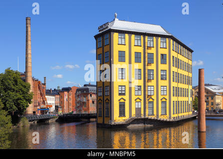 Norrköping, Schweden - 4. Juli 2014: Die industrielle Landschaft mit dem Strykjarnet (Eisenwerk, das gelbe Gebäude) im Fluss Motala auf der rechten Seite Stockfoto