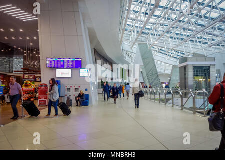 MINSK, Weißrussland - 01 Mai 2018: Unbekannter Touristen zu Fuß mit ihren Koffer und beobachten eine Abfahrt, Innerhalb des Flughafens von Minsk entfernt Stockfoto