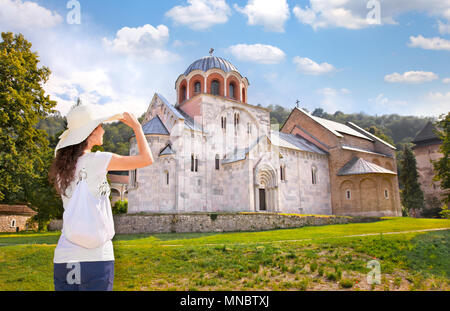 Schöne junge Frau mit weißen Hut vor Kloster Studenica, Serbien. Stockfoto