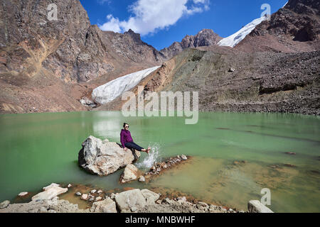 Touristische Frau mit runde Sonnenbrille entspannen auf dem Stein, in den Berg Stockfoto