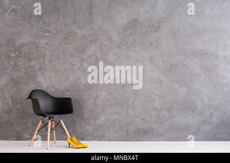 Neue schwarze und gelbe High Heels in geräumigen Innenraum mit Zement Wall Design stehend Stockfoto