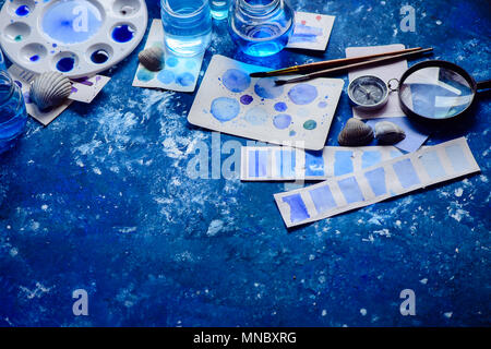 Artist Arbeitsplatz mit Aquarell Skizzen in Blau. Monochromer Malerei mit Gläsern, Farben und Pinsel. Zeichnung Meer Konzept mit kopieren Stockfoto
