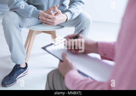 Psychologe Notizen während des Treffens mit seinem halbwüchsigen Patienten Stockfoto