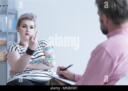 Rebellische Mädchen zeigt Mittelfinger zu Ihrem Therapeuten Stockfoto