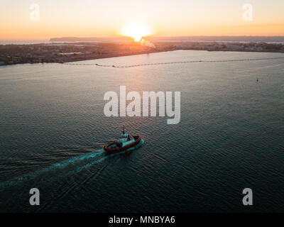 Luftaufnahme eines kleinen tugboat Segeln in der San Diego Bay Area bei Sonnenuntergang Stockfoto