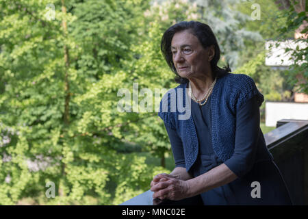 Ältere Frau, die auf dem Balkon des Hauses Stockfoto