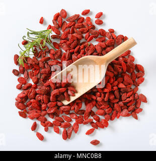 Stapel der gesunden Goji Beeren und woooden Schaufel auf weißem Hintergrund Stockfoto