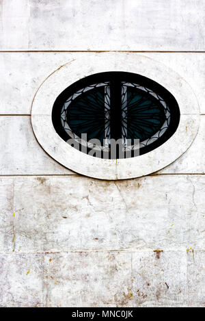 Elliptische Stein Design mit integriertem schwarzen schmiedeeisernen Gitter an der Wand von Gebäude in der Altstadt von Lissabon Stockfoto