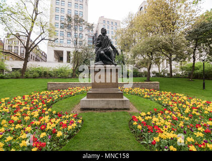 Statue des Dichters Robert Burns von Blumen in Embankment Gardens, London umgeben. Stockfoto