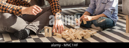 In der Nähe von Mann und Kind Vermittlung von Holz- Ziegel auf einem Teppich zu Hause Stockfoto