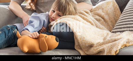 Panorama der lächelnde Junge spielt mit gelben Plüsch Hund beim Lügen mit seiner Mutter auf einer Couch Stockfoto