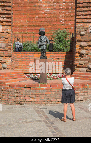 Warschau wenig Aufständische, eine Frau macht ein Foto von dem kleinen Denkmal zur Erinnerung an die Aufständischen teil, die von den Kindern in den Warschauer Aufstand von 1944 gespielt. Stockfoto