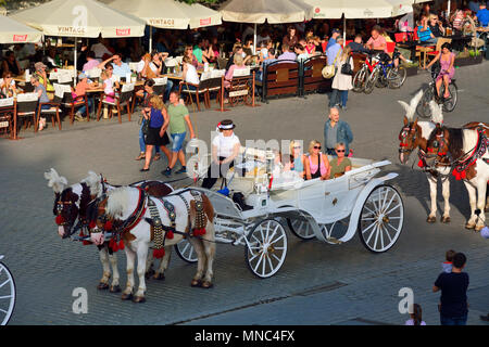 Traditionelle Pferdekutschen auf dem Marktplatz von Krakau. Polen Stockfoto