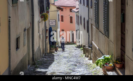 Istrien, Kroatien, April 2018 - Lokale Frau zu Fuß den engen gepflasterten Straße in der antiken Stadt Motovun Stockfoto