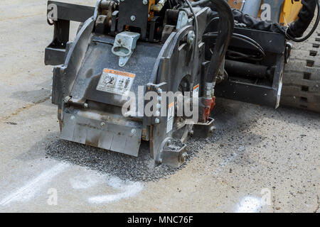 Fräsen von Asphalt für die Reparatur von Straßen, entfernt alte Asphalt Wiederaufbau Zubehör für Kompaktlader Stockfoto