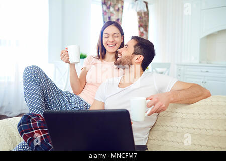 Ein junges Paar mit einem Laptop in der Hand Lachen in der Stockfoto