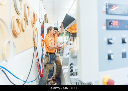 Zwei Tischler Reinigung Furnier Maschine in der Werkstatt Stockfoto