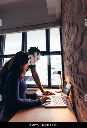 Seitenansicht der Frau Arbeiten am Laptop mit Mann durch. Paar mit Laptop im Innenbereich. Stockfoto