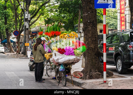 Hanoi, Vietnam - 27. Oktober 2017: Straßenhändler in Hanoi, Vietnam verkauft Blumen von seinem Fahrrad. Stockfoto