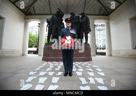 Flight Lieutenant Nigel Maler hält einen Kranz, wie er unter 53 Paaren von Flying Handschuhe an der Bomber Command Mahnmal im London Green Park, die die Männer, die in den Dambusters Razzien im Jahr 1943 starb, Teil einer Reihe von besonderen Veranstaltungen Kennzeichnung seit 75 Jahren eine mutige Band der Flieger nahmen an Eine der gewagtesten Luftangriffe des Zweiten Weltkrieges dar. Stockfoto