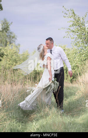 Schöne Leute Liebe küssen, Brautpaare, ein junges Paar, outdoor Session. Die Braut in einem weißen Kleid. Liebe, Hochzeit und Leidenschaft Stockfoto