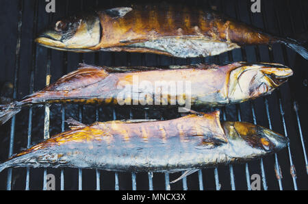 Geräucherter Fisch in der Räucherkammer. Drei Sardinen. Stockfoto