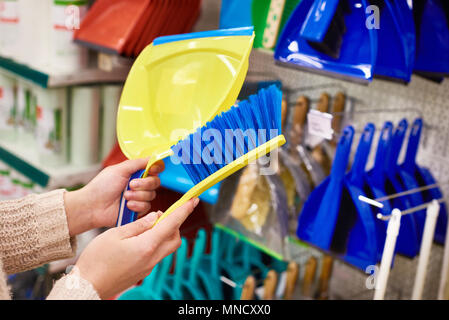 Frau Hände mit Reinigungsbürste und eine Kugel im Store. Stockfoto