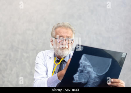 Leitender Arzt oder leitender Arzt oder Chirurg sind Kontrolle Schädel des menschlichen Kopfes über x-ray film im Untersuchungsraum mit kopieren. Stockfoto