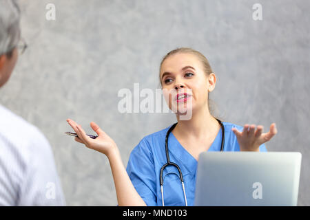 Weibliche Arzt, eine Konsultation zu ihren männlichen Patienten und erläutert medizinische Informationen und Diagnose in der Klinik oder im Krankenhaus. Stockfoto