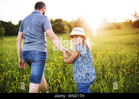 Vater mit einer kleinen Tochter auf einem Spaziergang im Frühling Natur. Stockfoto