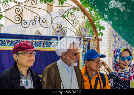 Isfahan, Iran - 23. April 2018: Einem älteren Iranischen Mullah trägt eine kufiya wirft mit Touristen im Hof der Moschee Jame Stockfoto