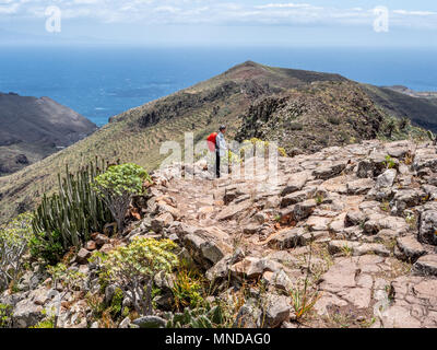 Weibliche Wanderer absteigend GR 131 National Trail in Richtung San Sebastian an der Küste von La Gomera auf den Kanarischen Inseln Stockfoto