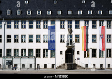 Rüsselsheim, Deutschland - 11 April 2018: Eine Bushaltestelle und verschiedene Flaggen vor dem hellen Fassade des Rathauses, das am 11. April 2018 in Ruesselsheim. Stockfoto