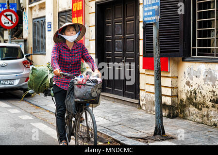 Hanoi, Vietnam - 27. Oktober 2017: Frau ist Reiten Fahrrad im alten Viertel von Hanoi, Vietnam. Stockfoto