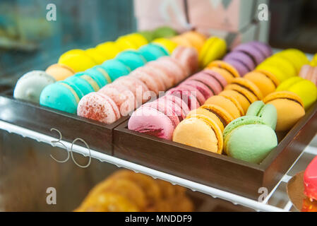 Sortiment Bunte macarons für den Verkauf im Shop. Reihen von makronen in Candy Shop, Storefront mit Süßigkeiten, Cafe präsentieren. Traditionelle französische Mandel ca Stockfoto