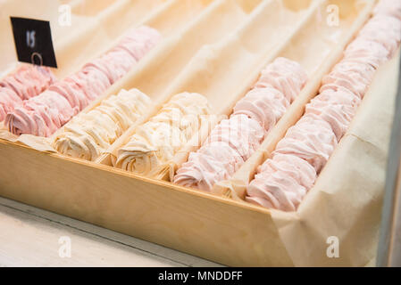 Nicht vollständige Reihen von Obst rosa und gelb Marshmallow, Zephyr Desserts im Holzkasten in Candy shop Storefront, Cafe präsentieren. Weiche selektiven Fokus. Raum Stockfoto