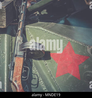 Maschinenpistole der PPSh Shpagin, lehnt sich an die Rüstung eines Tanks. Der rote Stern, als Emblem der Sowjetischen Armee, auf die Rüstung des Tank angesaugt Stockfoto