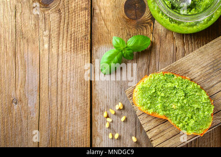 Hausgemachte Pesto, Brot. Zutaten. Käse, Knoblauch, Basilikum, Pinienkernen, Olivenöl auf einem alten Holztisch Stockfoto