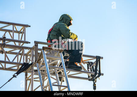 Industriekletterer in Uniform sitzen ts auf einem Gebäude Struktur Stockfoto