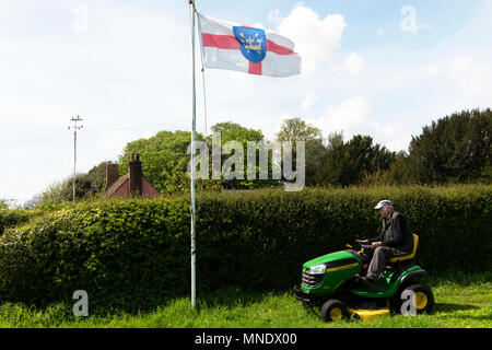 Alter Rentner mit aufsitzendem Rasenmäher, Bawdsey, Suffolk, England. Stockfoto