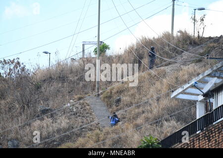 Caracas, Miranda, Venezuela. 16 Mai, 2018. SEBIN offizielle Uhren mit seiner Waffe in der Hand von einem Berg neben dem Helicoide. Angehörige von politischen Gefangenen finden am Sitz der Bolivarischen National Intelligence Service (Sebin) in El Helicoide, verurteilte eine unregelmäßige Situation, in denen gemeinsame Gefangenen einen Aufstand anspruchsvolle Transfer in andere Gefängnisse erzeugt. In der Mitte der Meuterei, die politischen Gefangenen, Gregory Sanabria, wurde geschlagen, als er versuchte, die Situation zu beruhigen. Daniel Ceballos Frau, Patricia Ceballos, angeprangert, dass ihr Mann in Gefahr mit dem gemeinsamen Häftlinge, die dm Stockfoto