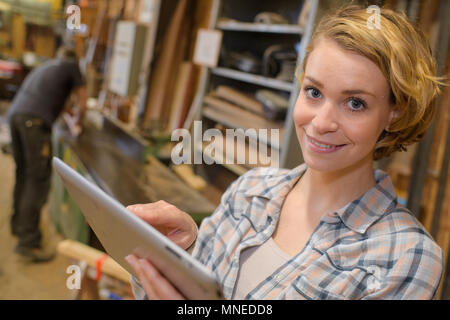 Frau mit Tablette in Schreinerei Stockfoto