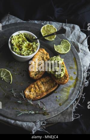 Gegrilltes Brot mit einem würzigen Avocado verteilen Stockfoto