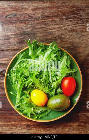 Frischer grüner Salat mit bunten Tomaten (von oben gesehen) Stockfoto