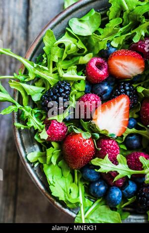 Grüner Salat mit Rucola und Beeren Stockfoto