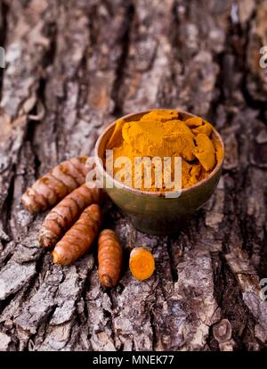 Gelbwurz, ganze und Boden auf ein Stück Rinde Stockfoto