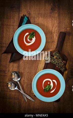 Tomatensuppe mit Basilikum und Crème fraîche Stockfoto