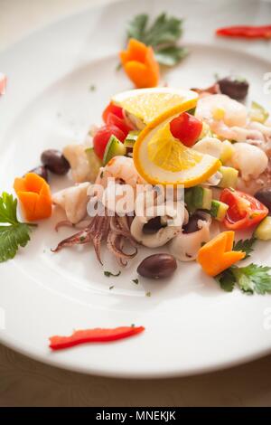 Meeresfrüchte Salat mit Tintenfisch, Garnelen, Zucchini, Oliven und Cocktailtomaten Stockfoto