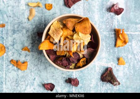 Buntes Gemüse Chips in eine Schüssel geben. Stockfoto